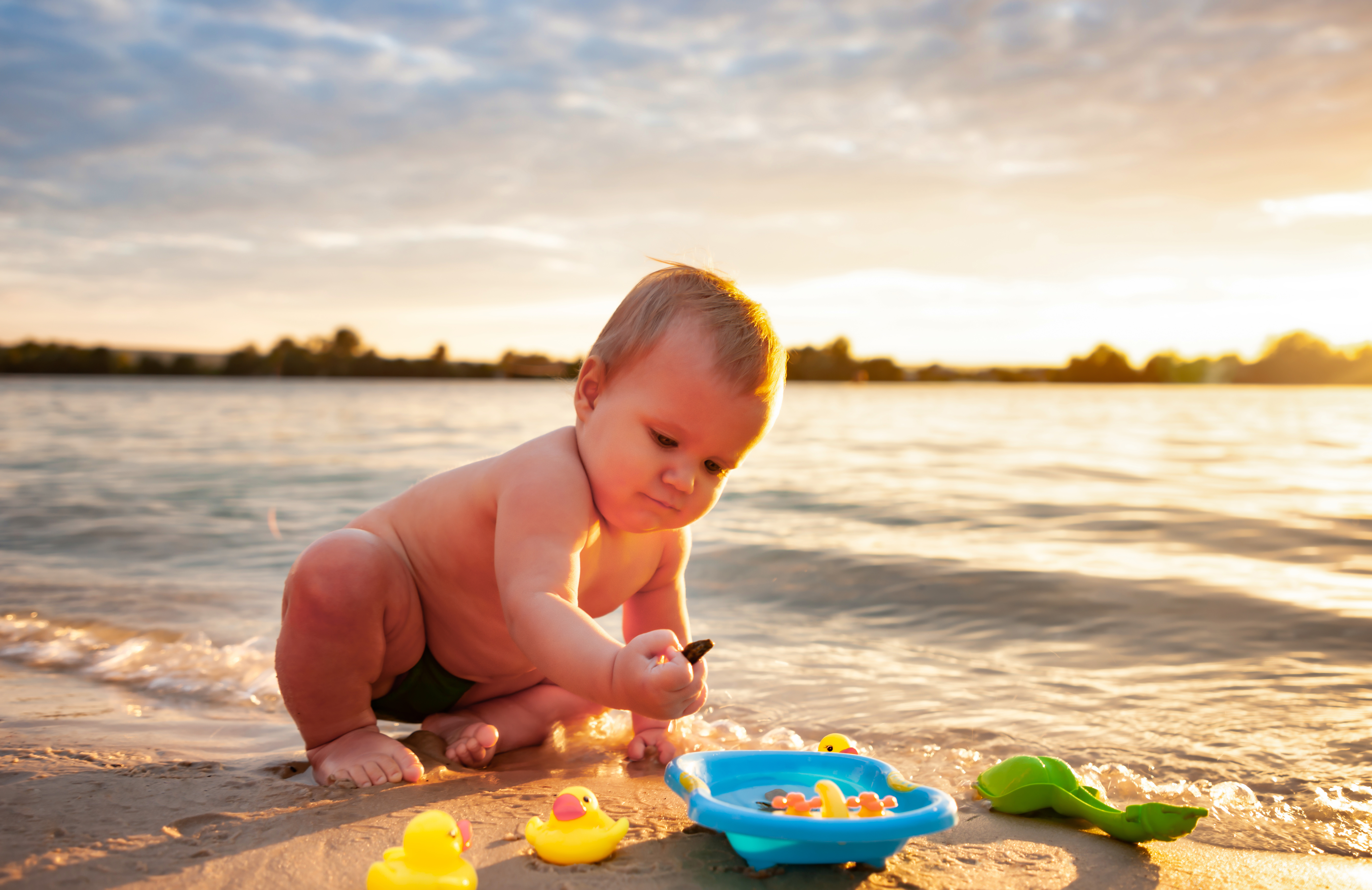 infant playing on the beach