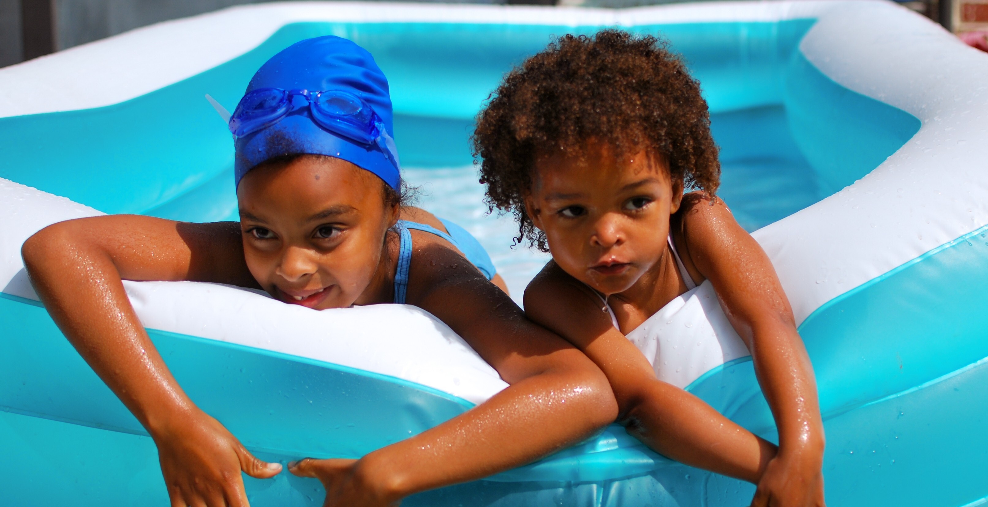 two young kids playing outside in water
