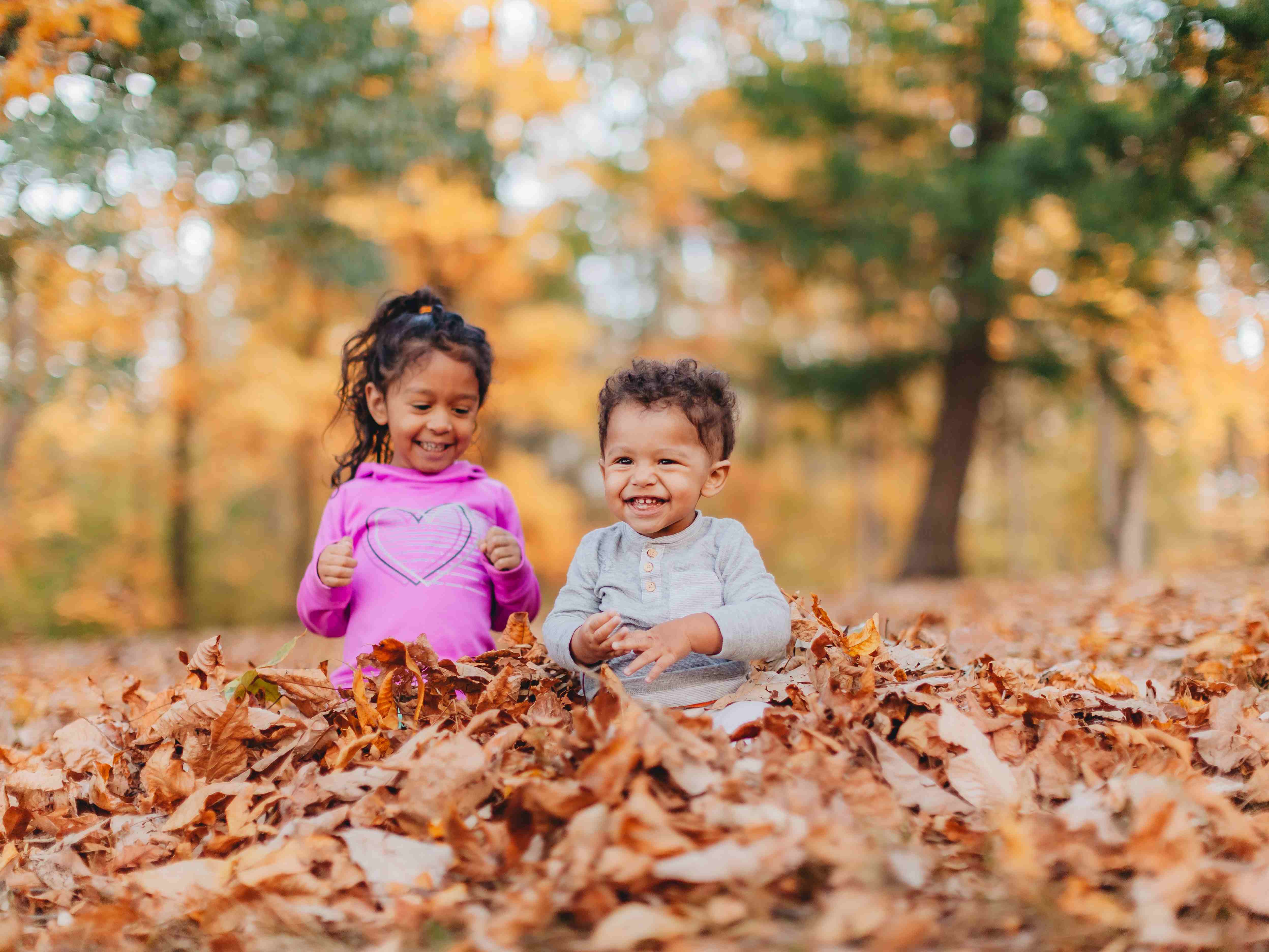 kids playing in fall leaves 